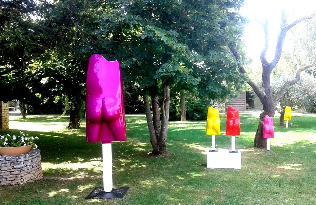 Sculpture contemporaine dans un jardin, de couleurs Rose, jaune et rouge