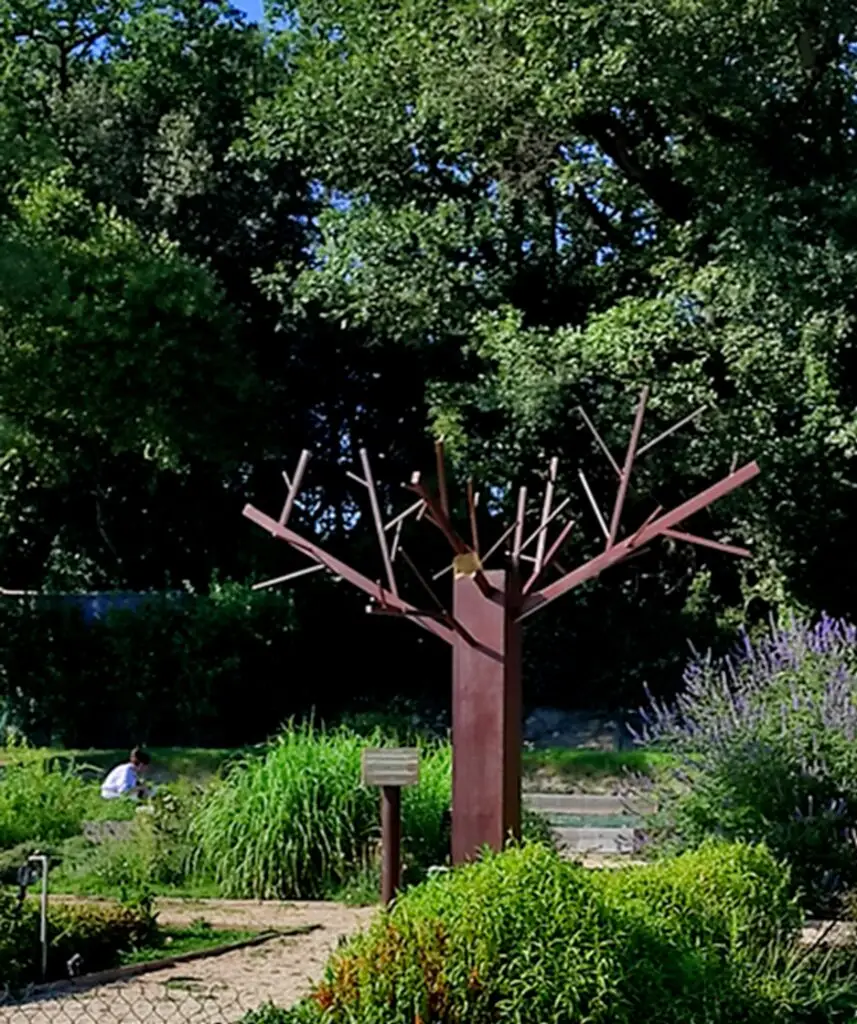 Sculpture métallique d'un arbre, dans un jardin